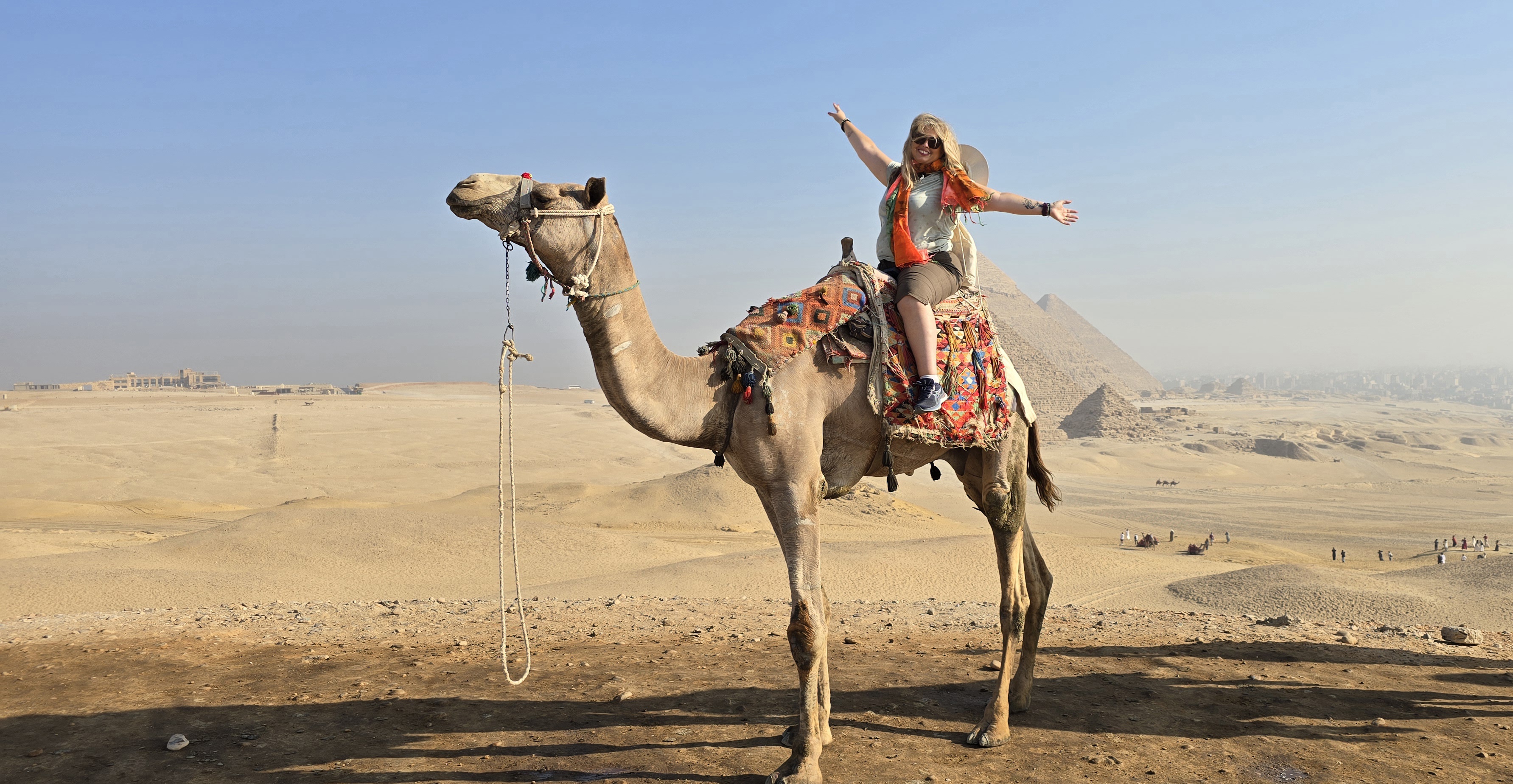 Serena in groppa a un cammello davanti alle piramidi di Giza, Egitto